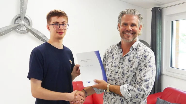 Niklas schüttelt Timo die Hand, Zertifikat ist zu sehen